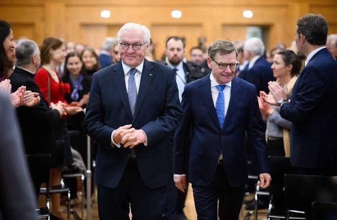 Frank-Walter Steinmeier walks through a hall of applauding guests at an official event