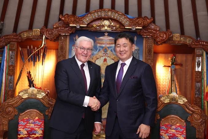 Frank-Walter Steinmeier and Mongolian President Ukhnaagiin Khurelsukh shake hands inside a richly decorated ceremonial ger
